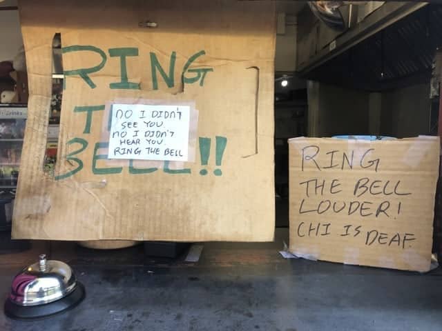 Handmade signs asking customers to ring the bell louder