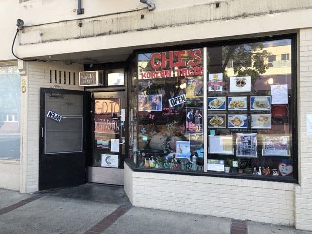 Chi's storefront window covered in flyers and merchandise