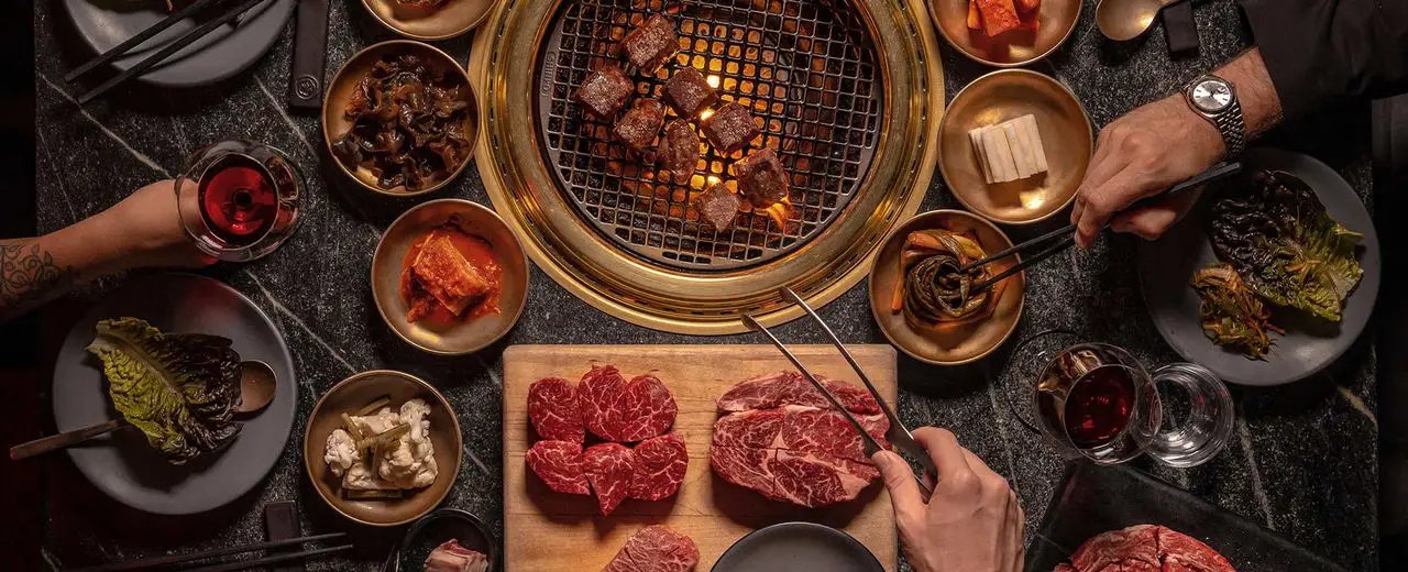 Korean BBQ spread with raw cuts and banchan at COTE