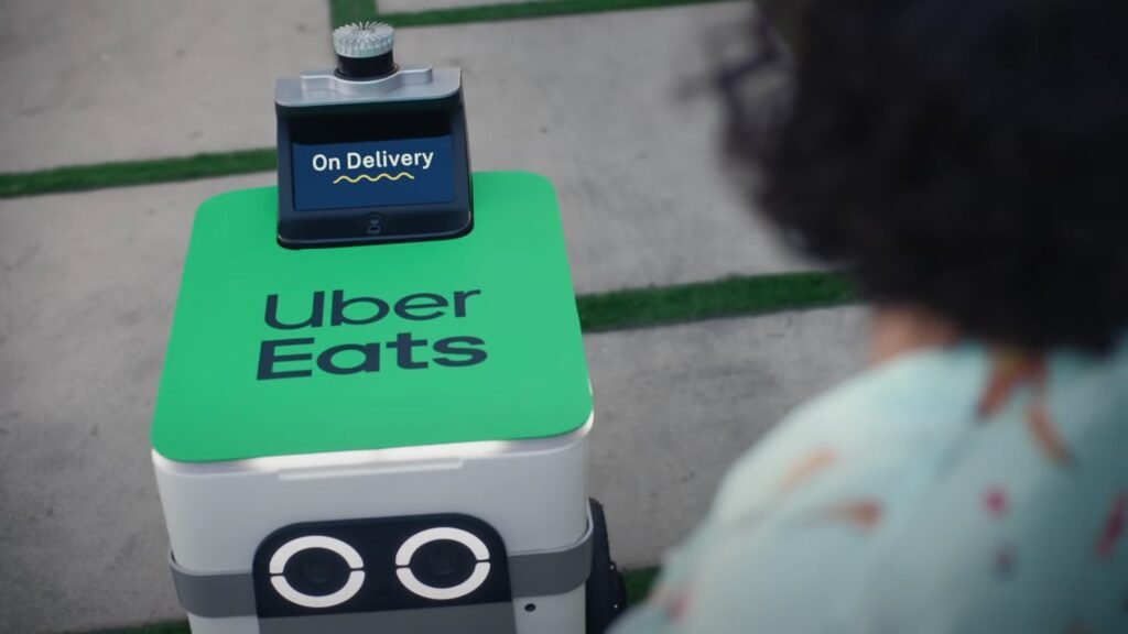 A Serve Robotics sidewalk delivery robot with an “On Delivery” screen